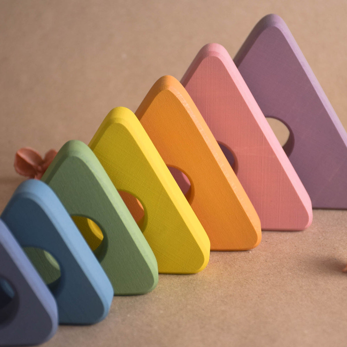 Ring stacking toy made from wood, with pastel-colored triangular rings