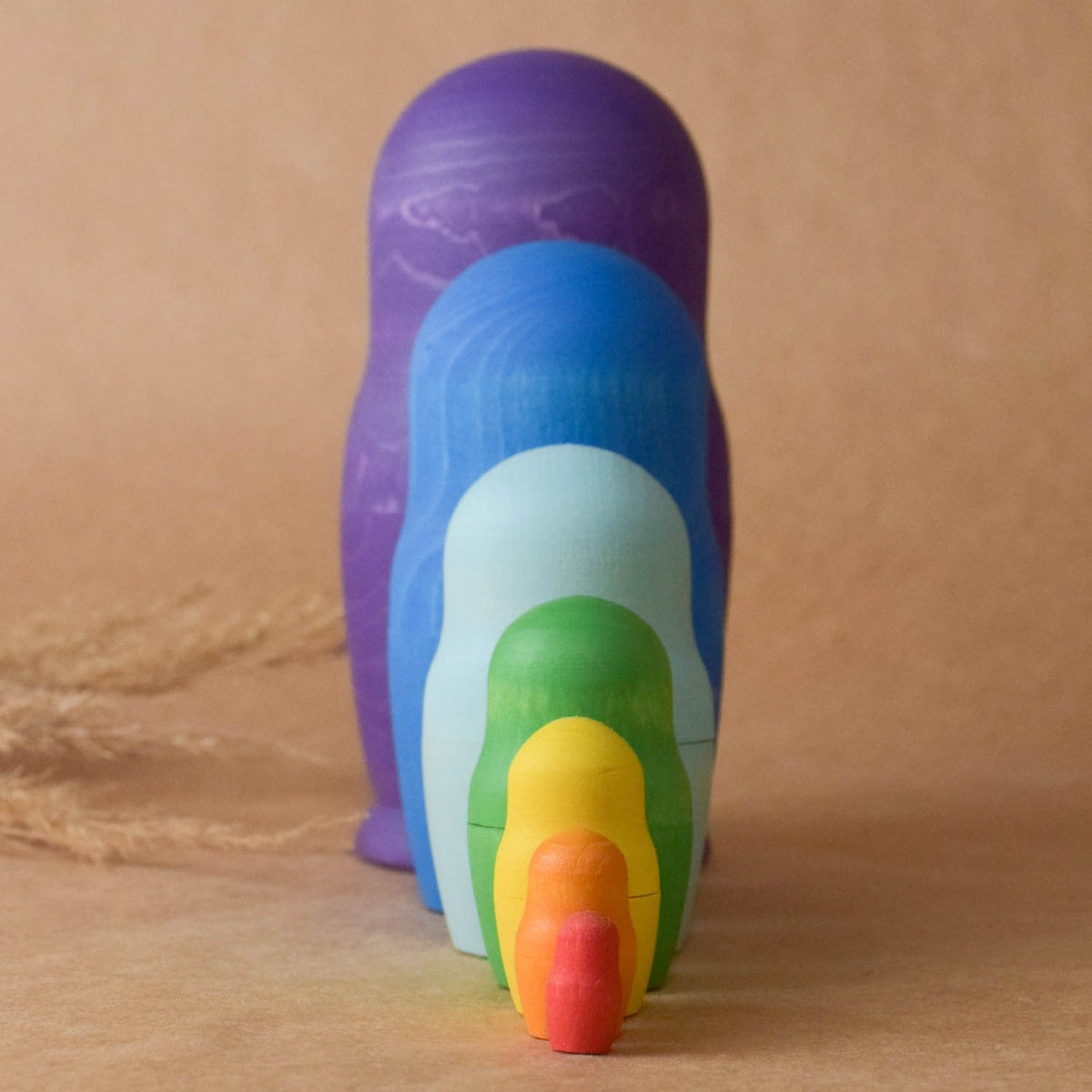Wooden nesting figures in bright rainbow colors