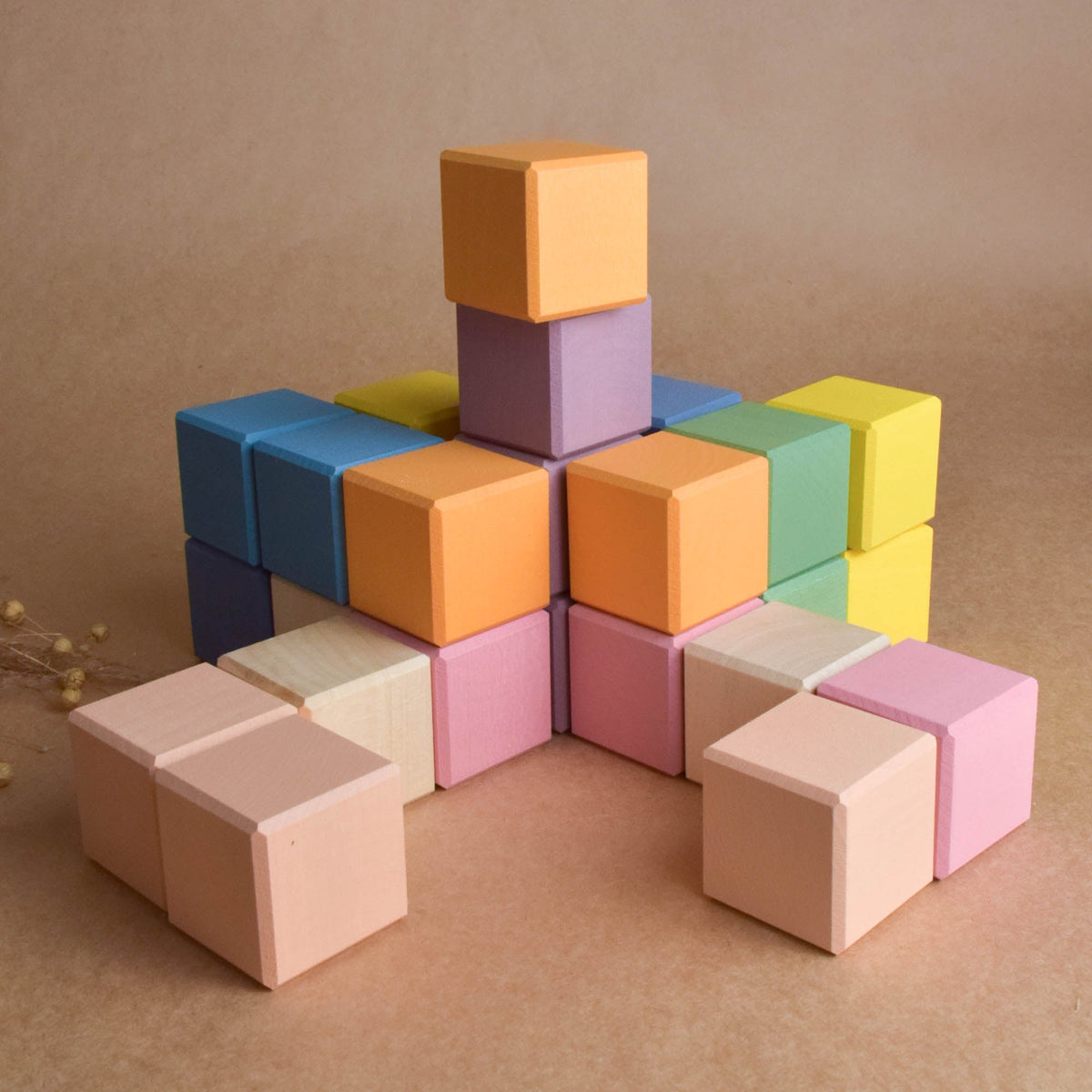 Close product view of the Pastel Cubes in Cube wooden rainbow stacker, finished with natural colored wax.