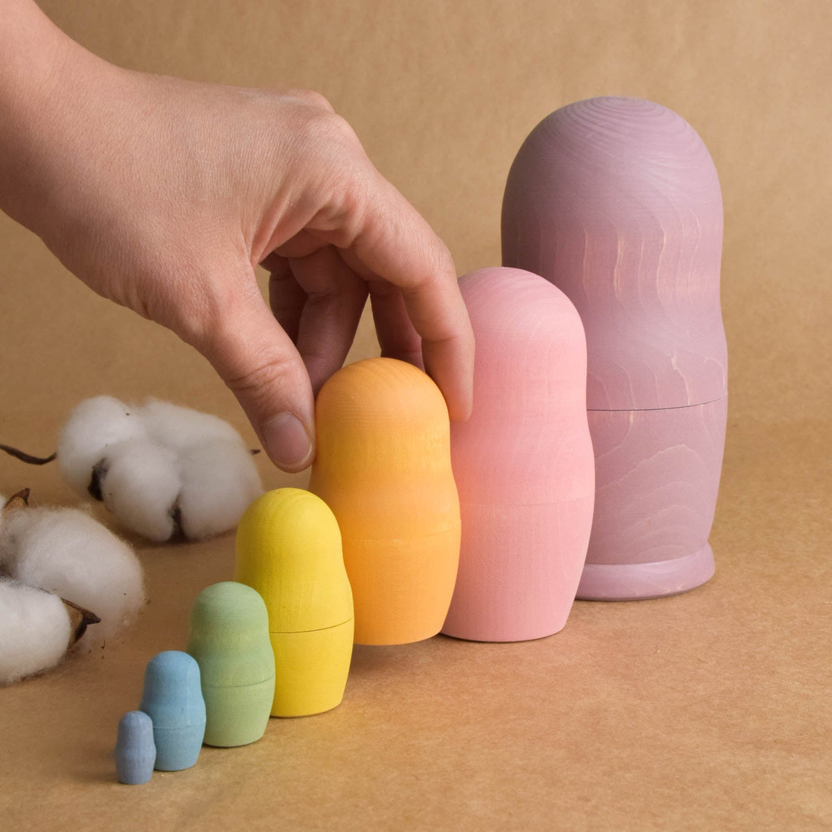 Wooden nesting figures in soft rainbow colors