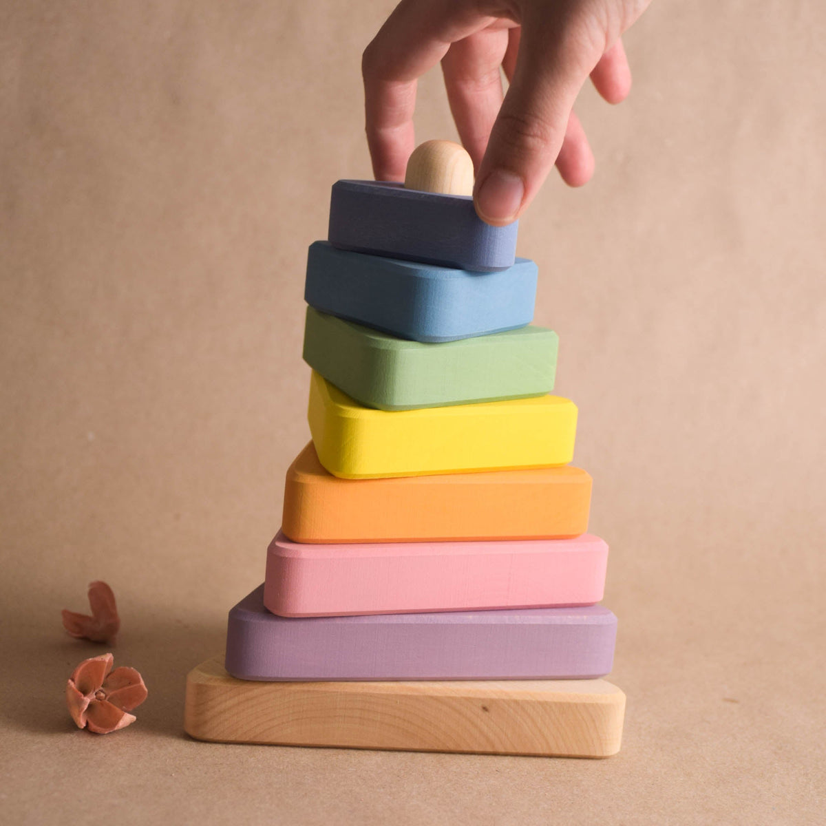 Stacking toy with pastel-colored triangular rings made from wood