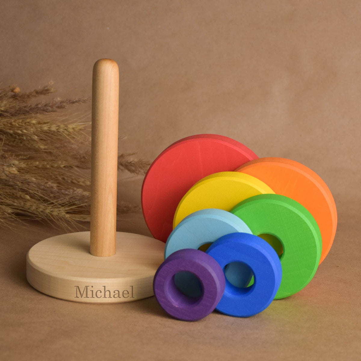 Stacking toy with rainbow-colored rings handmade from natural solid wood