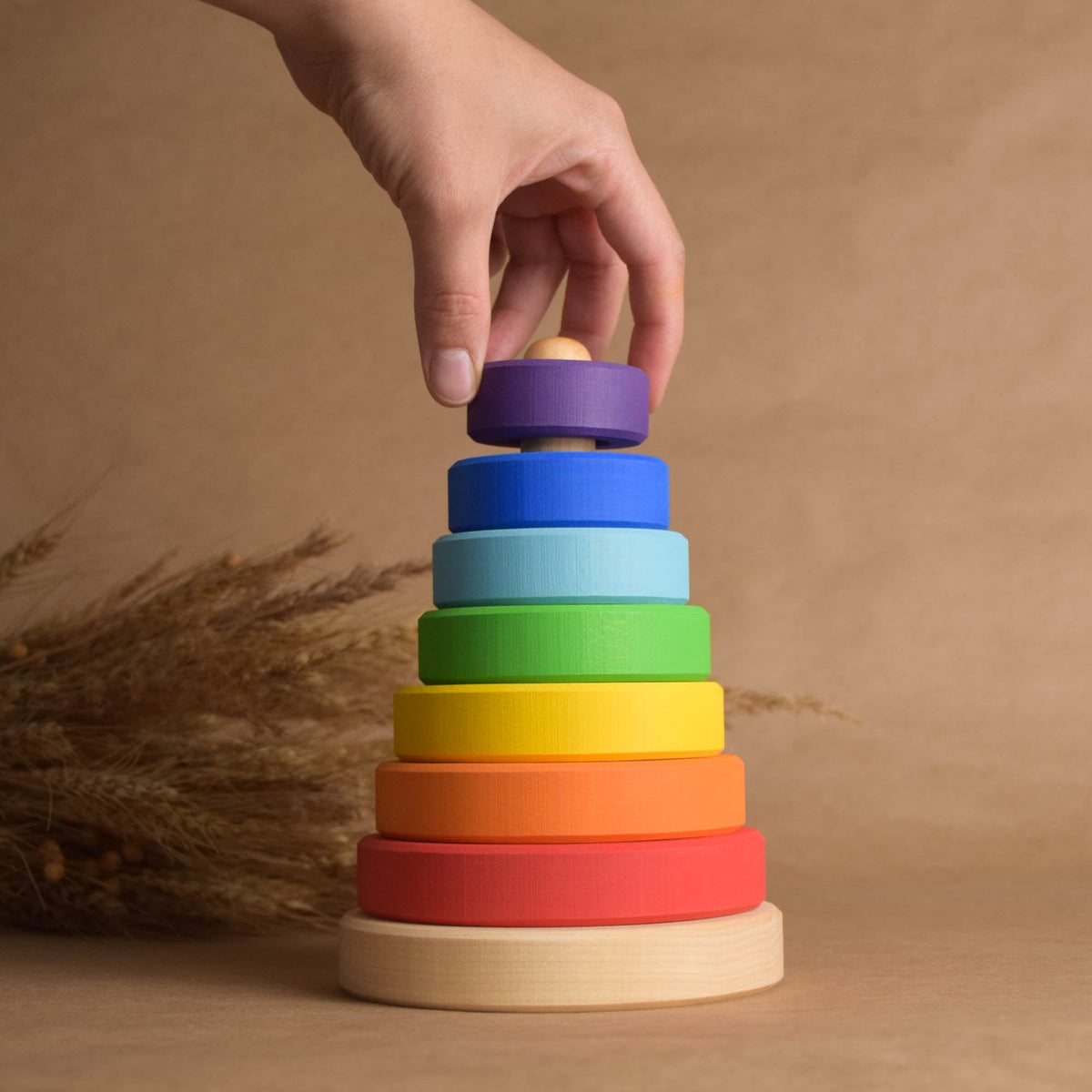 Ring stacking toy handmade from solid wood, with rainbow-colored rings