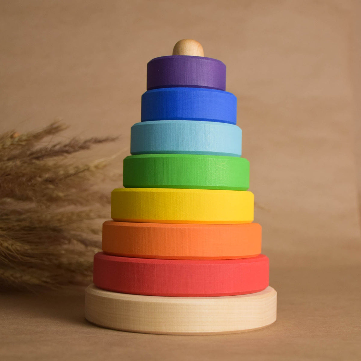 Ring stacking toy handmade from wood, with rainbow-colored rings