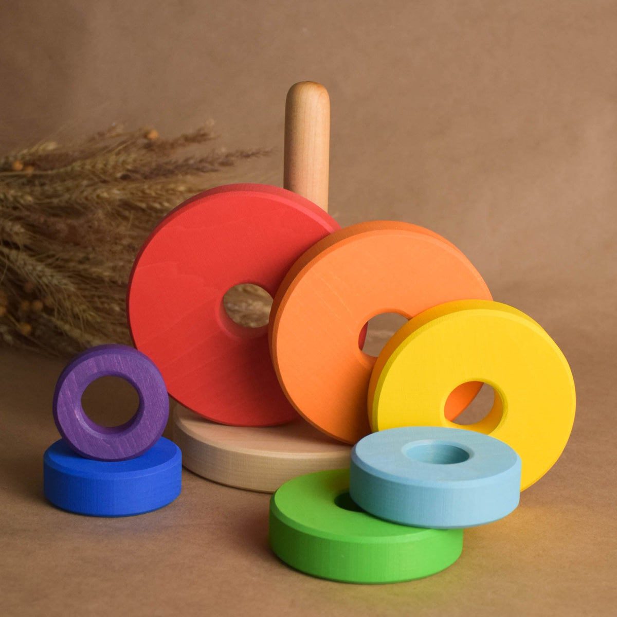 Wooden stacking toy with rainbow-colored rings