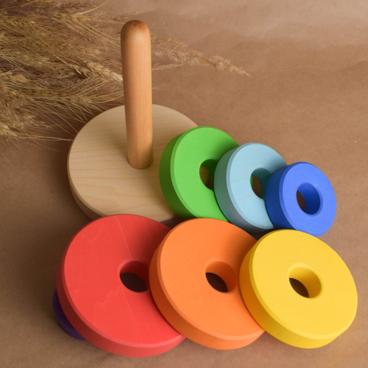 Wooden stacking toy with rainbow-colored rings