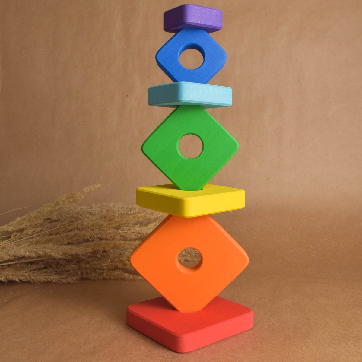 Wooden stacking toy with rainbow-colored square rings