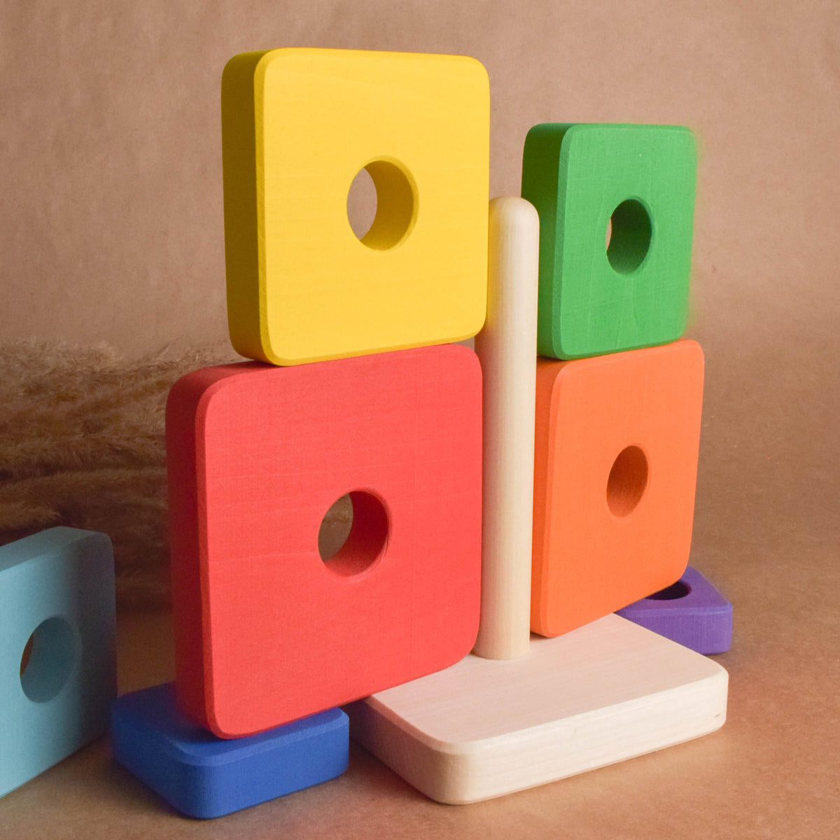 Stacking toy with rainbow-colored square rings made from wood