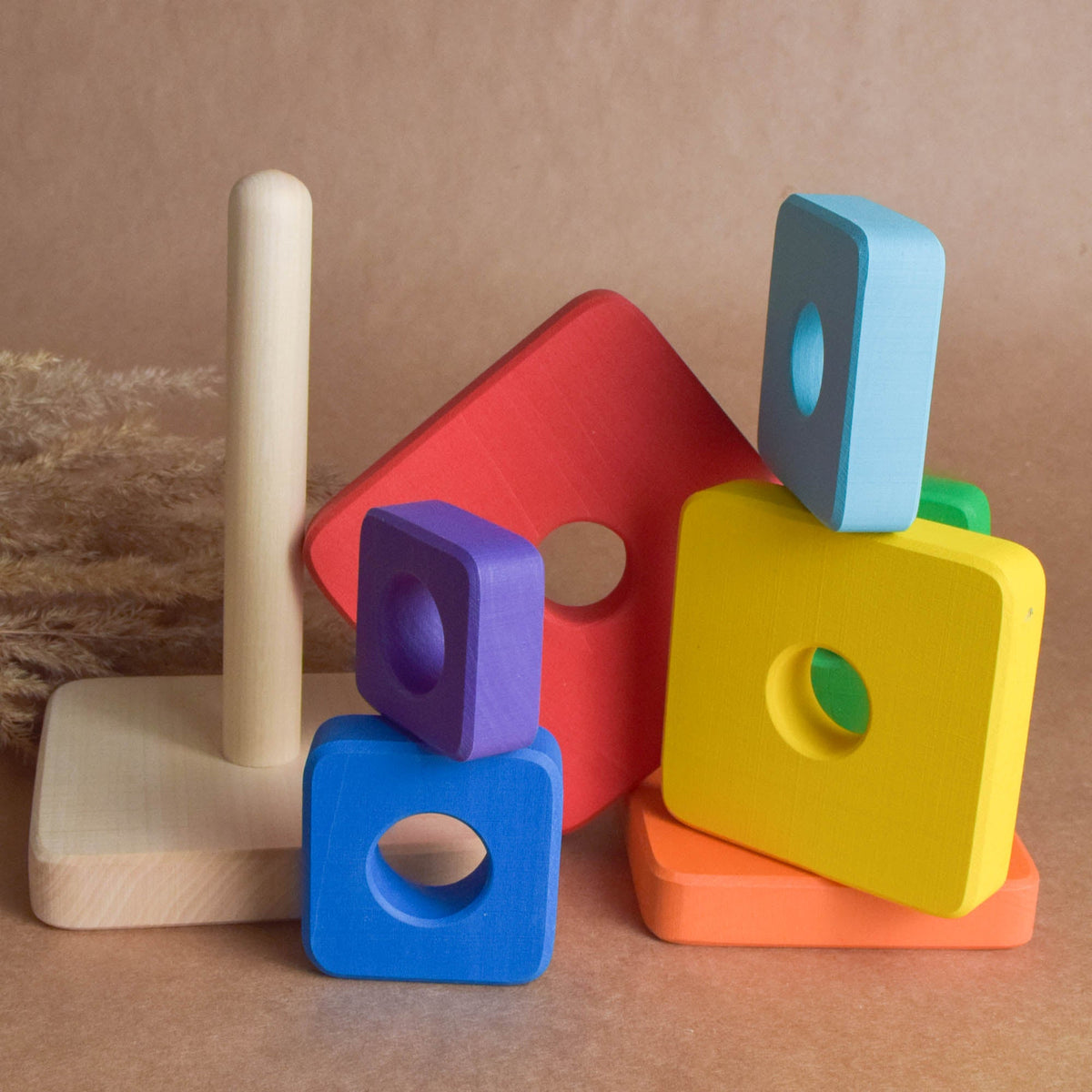 Ring stacking toy made from wood, with rainbow-colored square rings