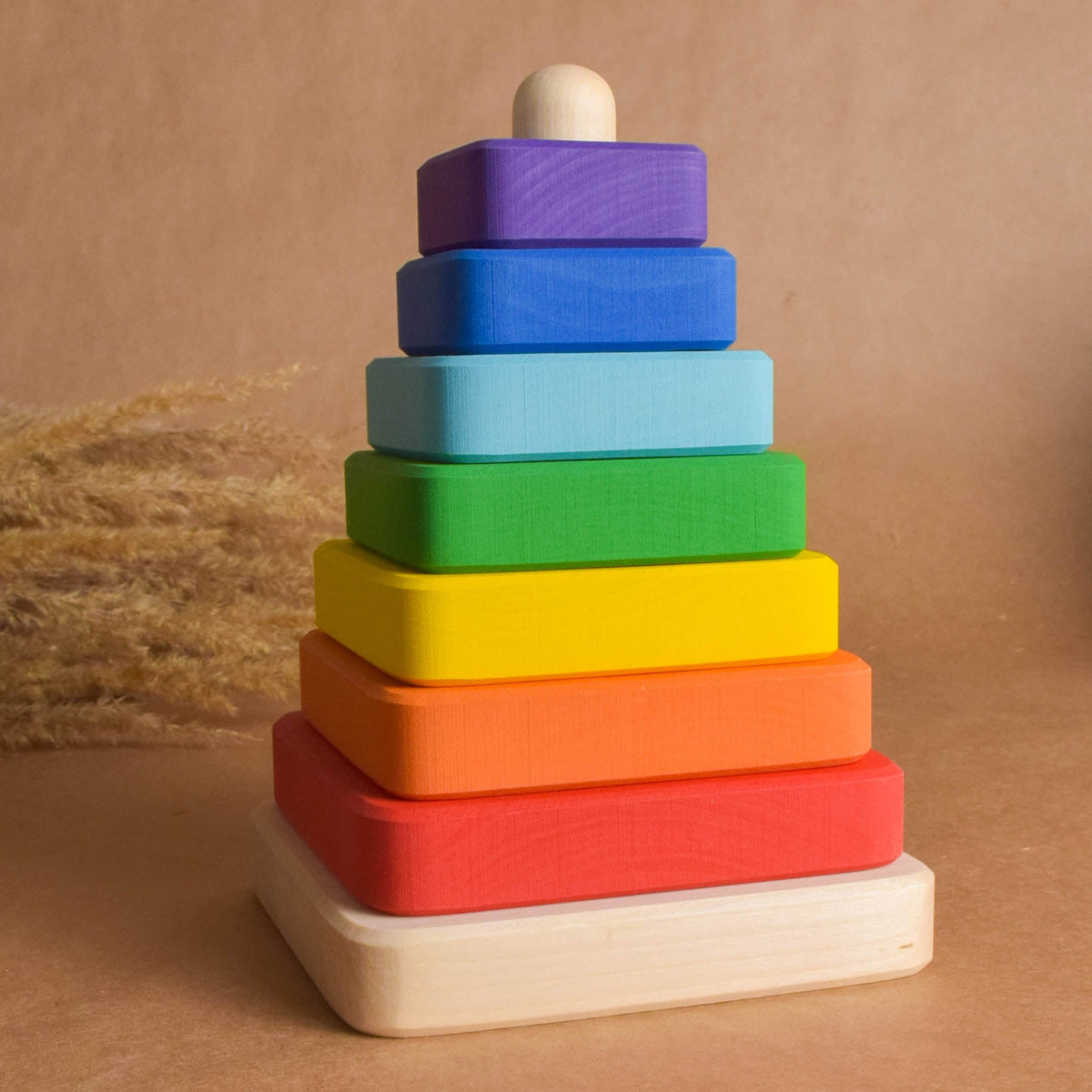 Wooden stacking toy with rainbow-colored square rings
