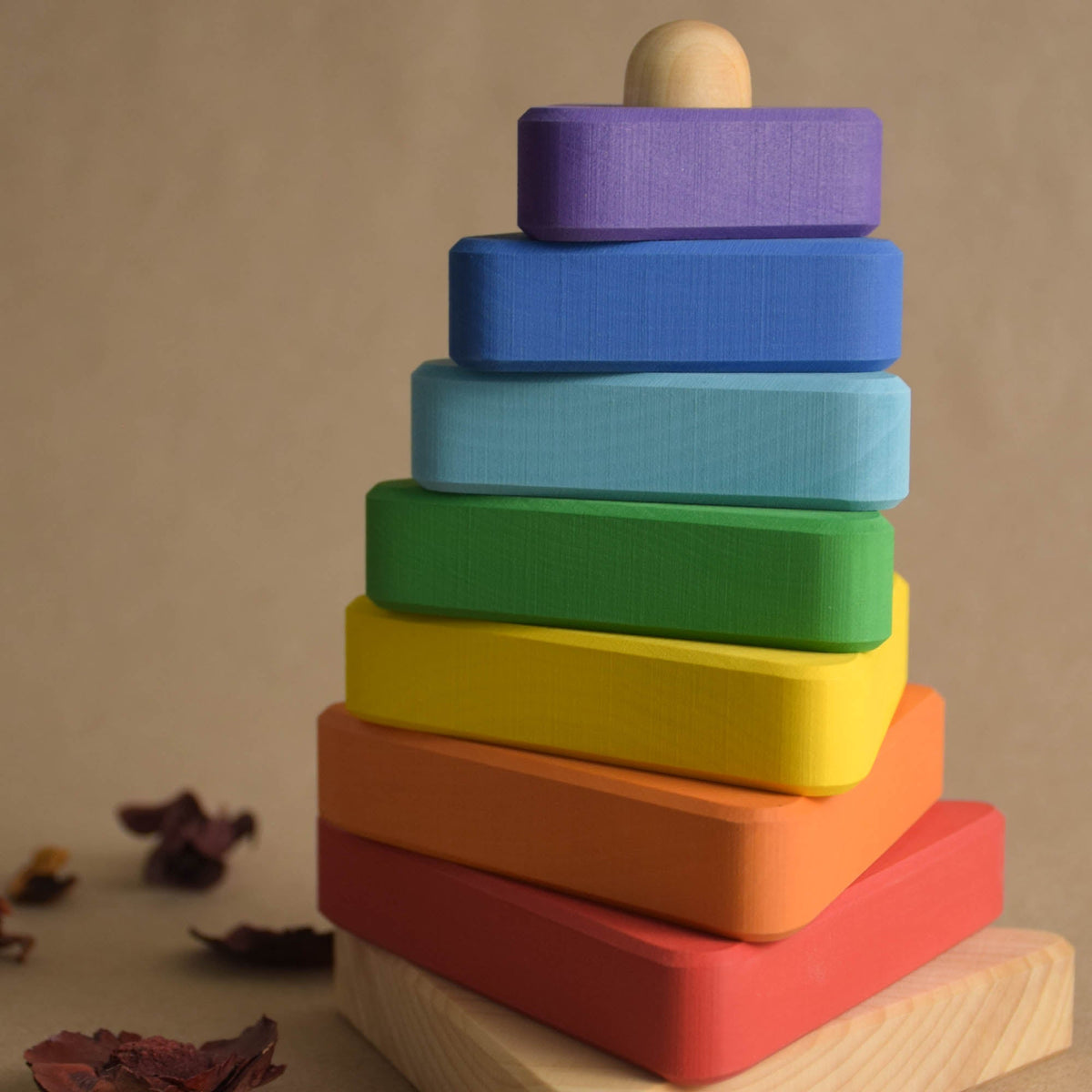Stacking toy with rainbow-colored triangular rings made from wood