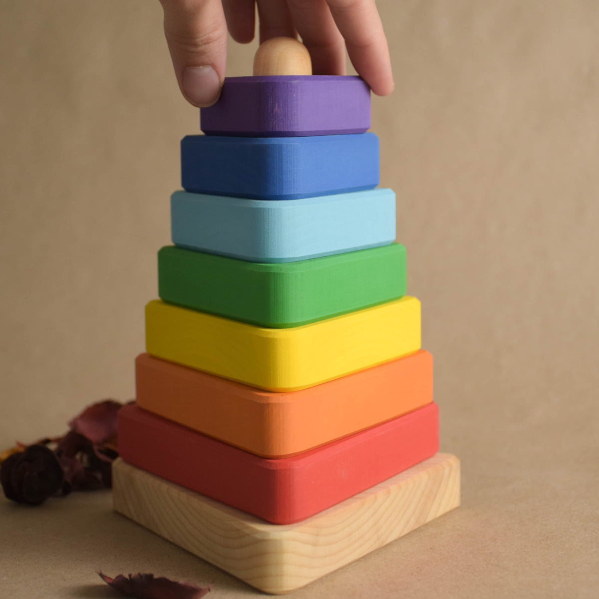 Ring stacking toy made from wood, with rainbow-colored triangular rings