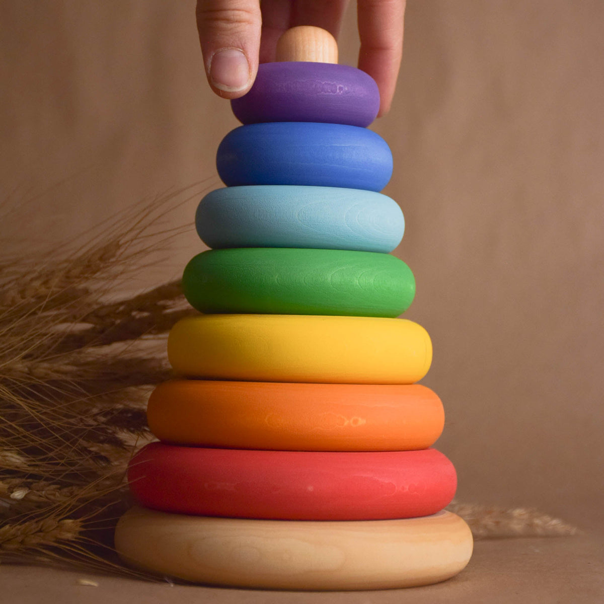 Stacking toy with rainbow-colored turned rings made from wood