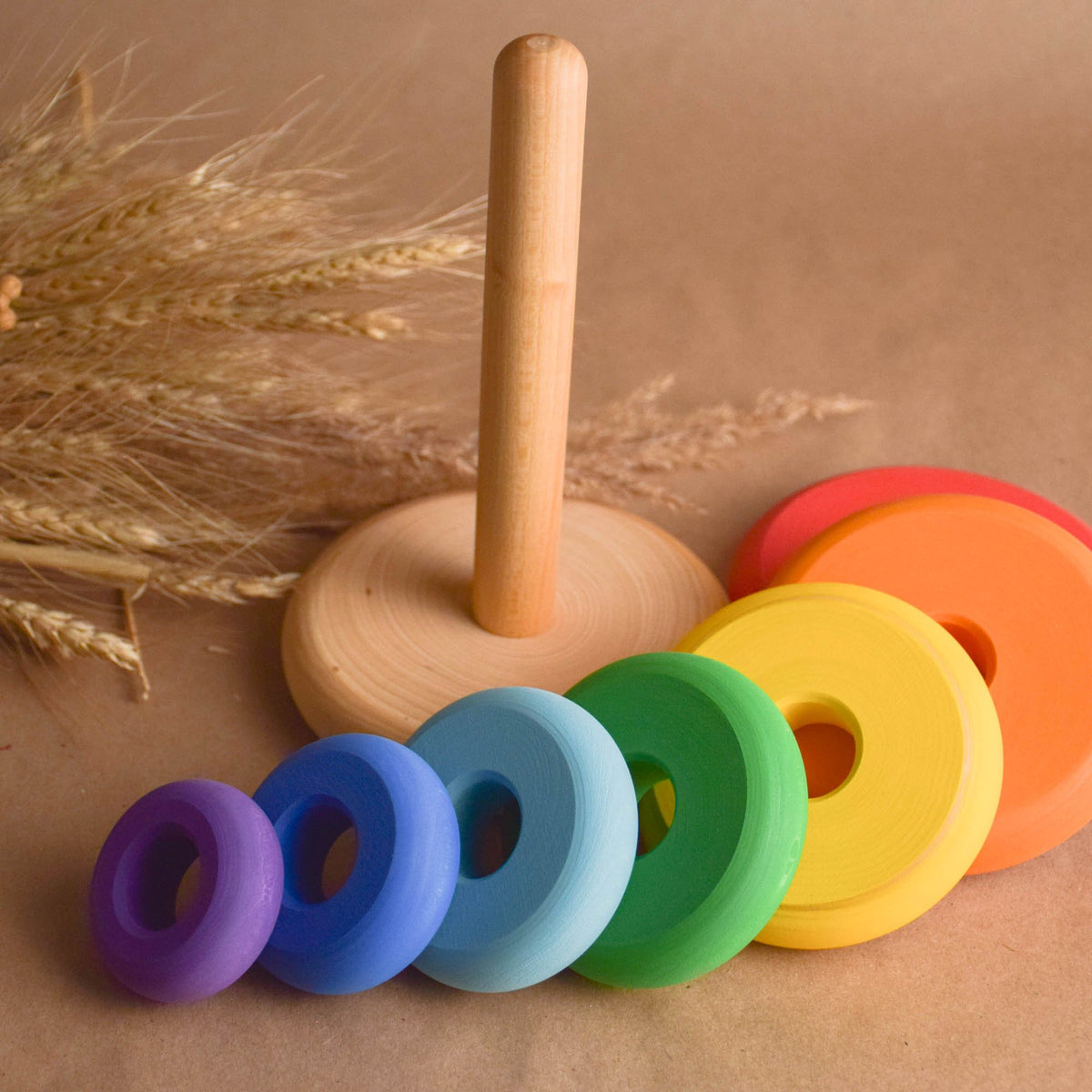 Ring stacking toy made from wood, with rainbow-colored turned rings