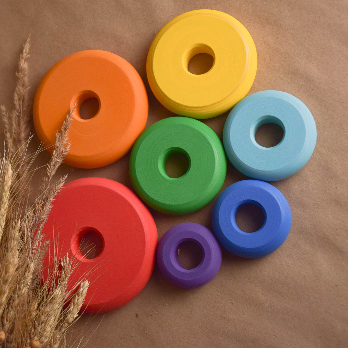 Wooden stacking toy with rainbow-colored turned rings