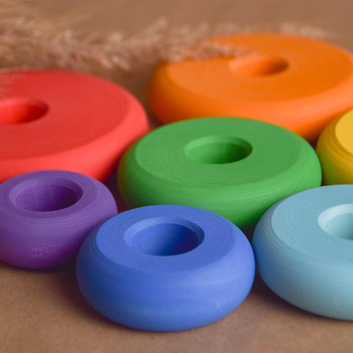 Wooden stacking toy with rainbow-colored turned rings