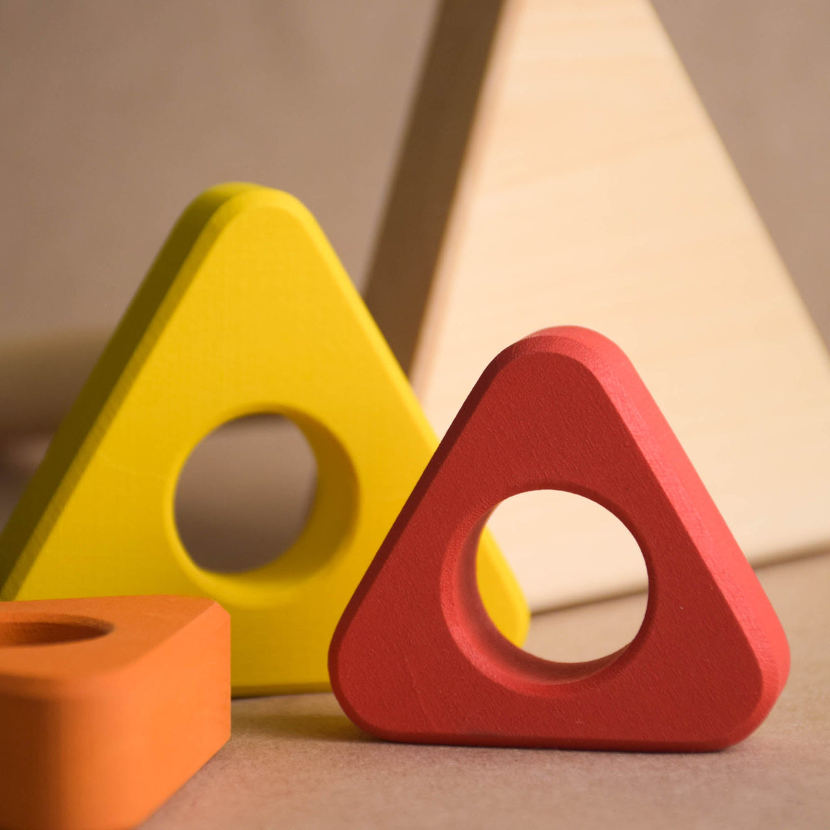 Ring stacking toy made from wood, with triangular rings