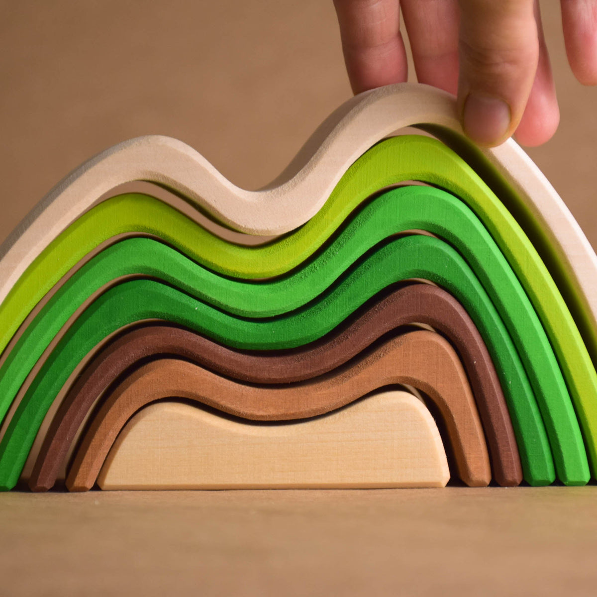 Handmade Montessori colored mountain stacking toy in linden wood with a natural wax-and-oil finish