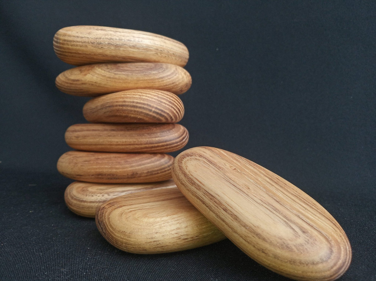 Smooth pebble-shaped blocks made from green acacia