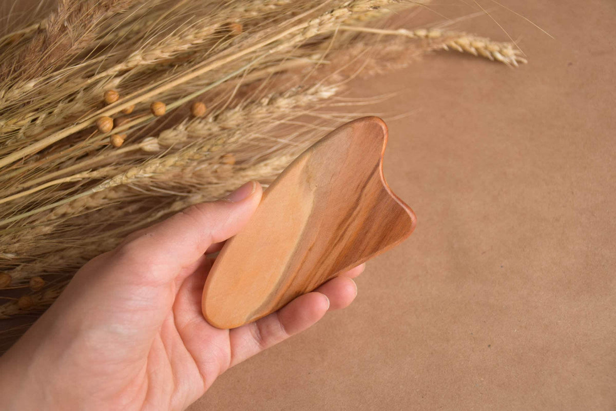 Gua sha facial massage tool in heart-shaped elm wood