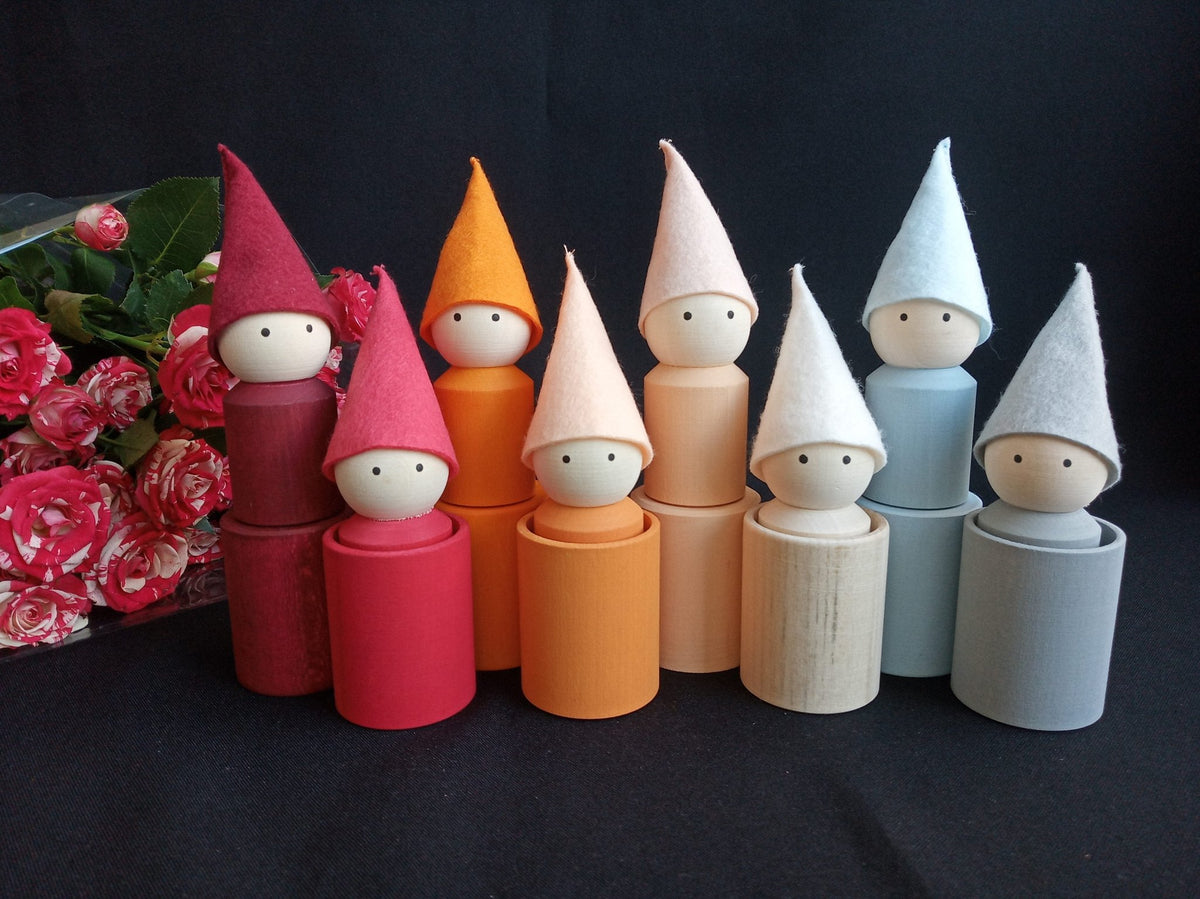 Neutral-colored wooden peg dolls with hats and cups