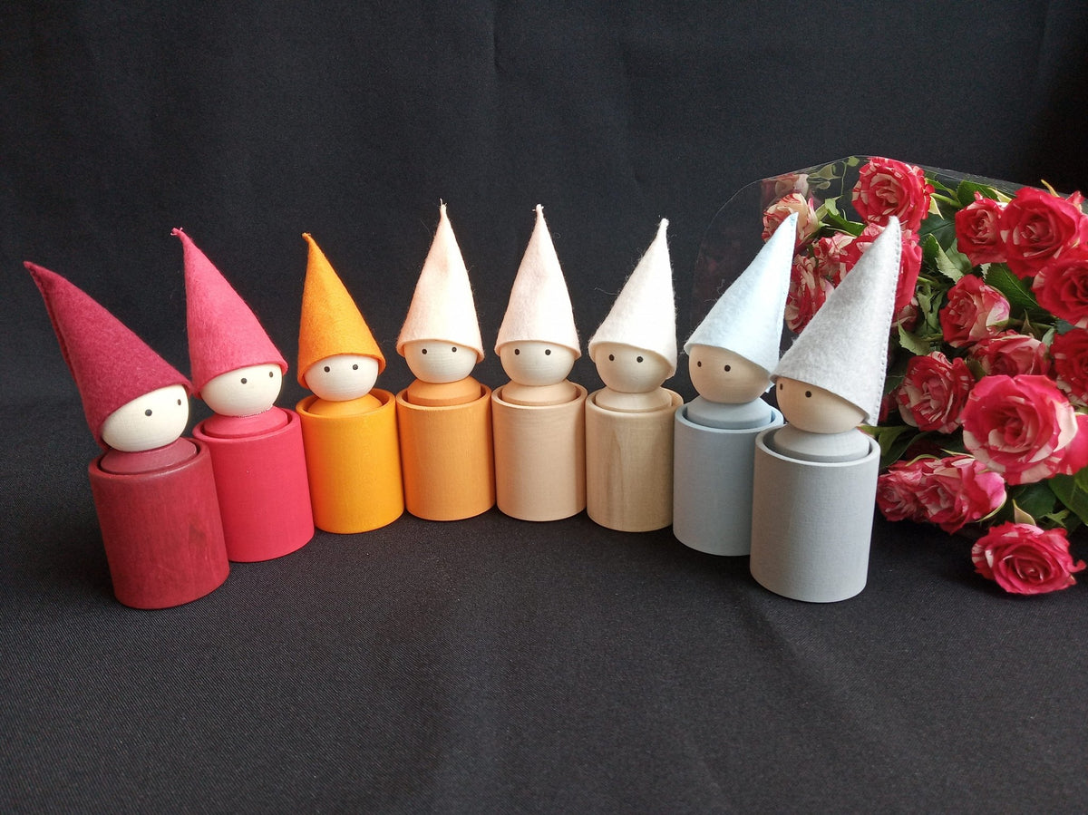 Wooden cups and peg dolls with neutral-colored hats