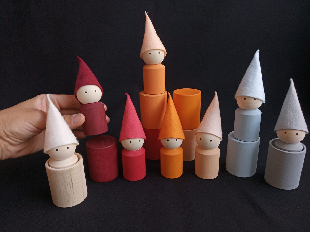 Wooden cups and peg dolls with neutral-colored hats