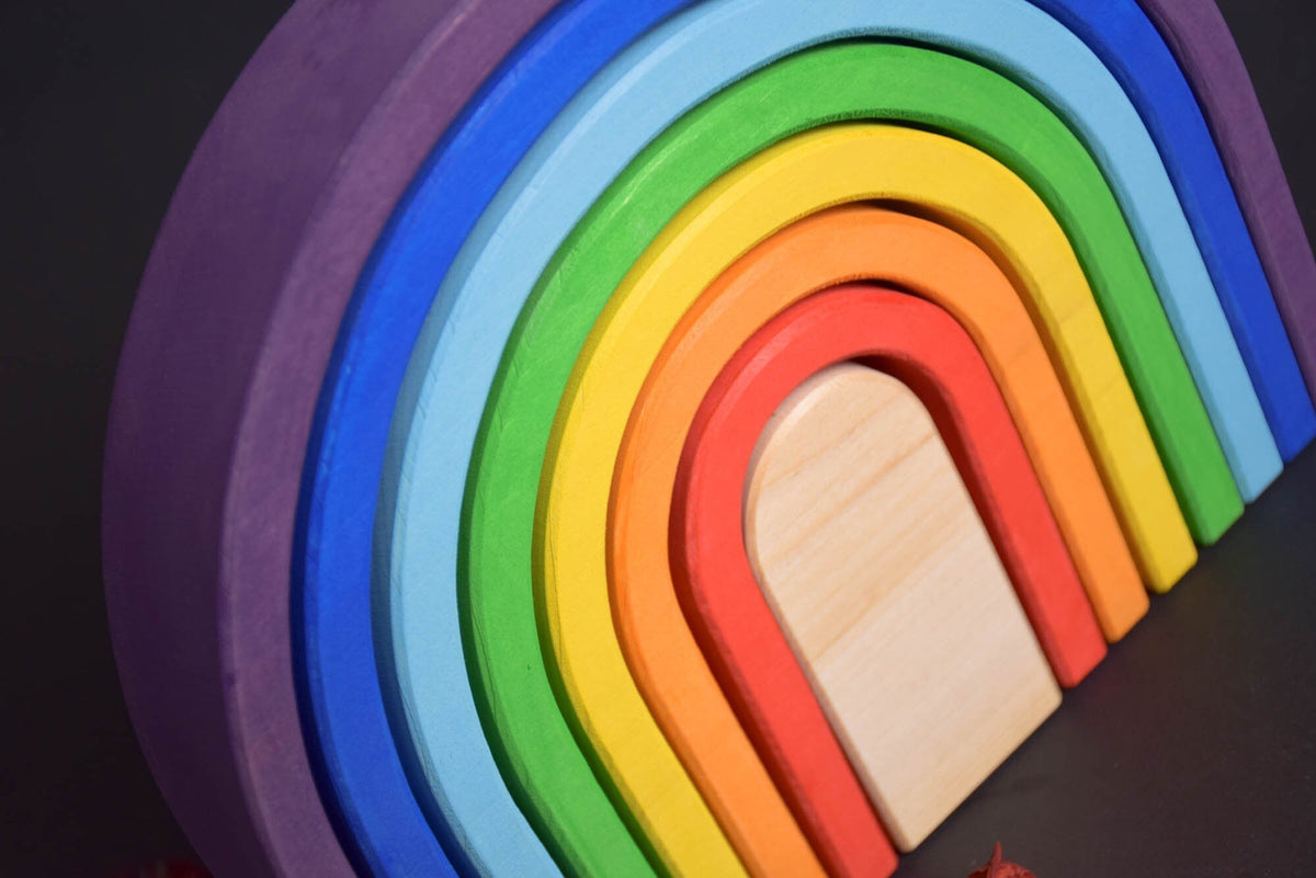 Handmade Montessori oval rainbow stacker in linden wood with a natural colored wax-and-oil finish