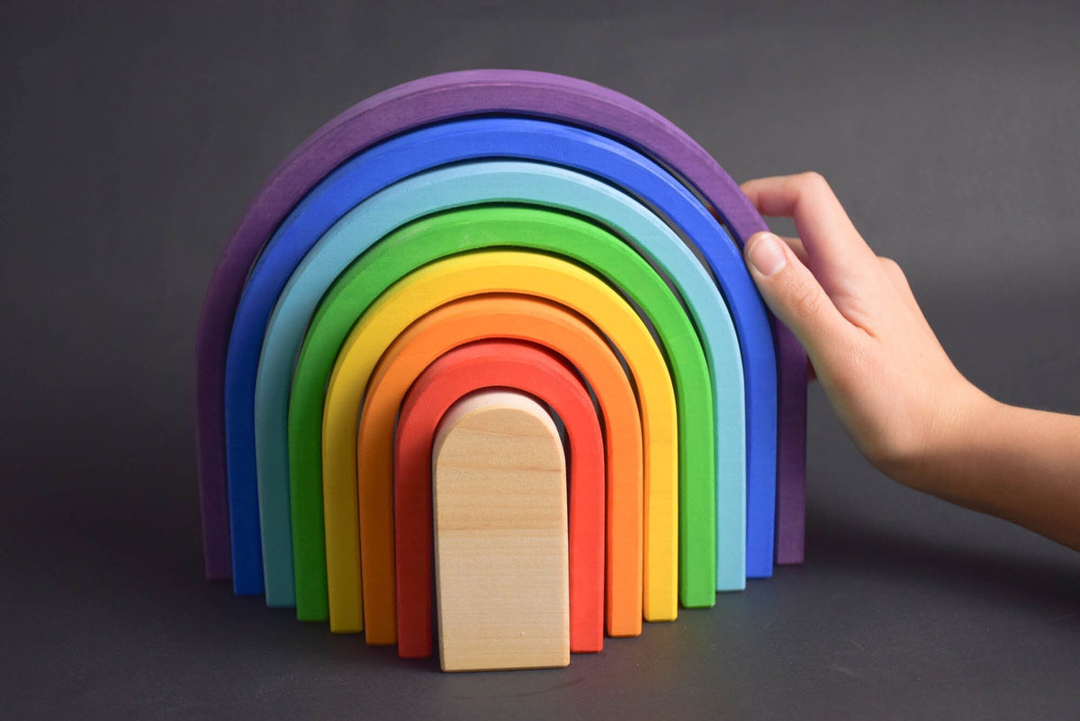 Handmade Montessori oval rainbow stacker in linden wood with a natural colored wax-and-oil finish
