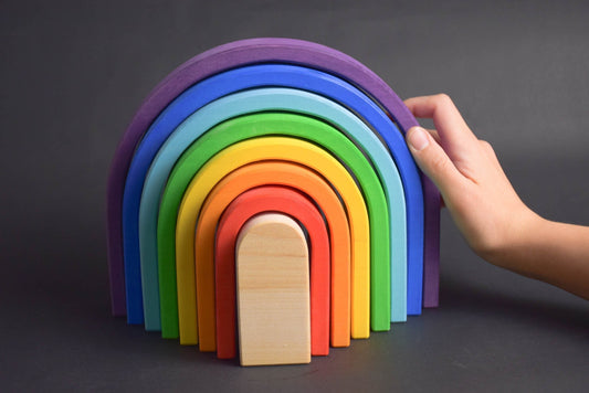 Handmade Montessori oval rainbow stacker in linden wood with a natural colored wax-and-oil finish
