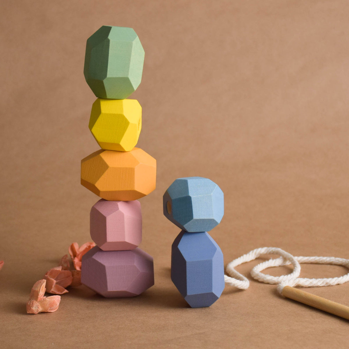 Handcrafted pastel wooden lacing stones and wooden needle cord set together as a natural educational gift for toddlers
