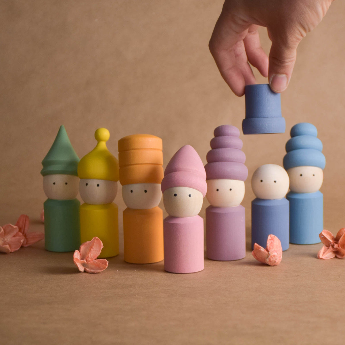 Wooden peg dolls with pastel-colored hats