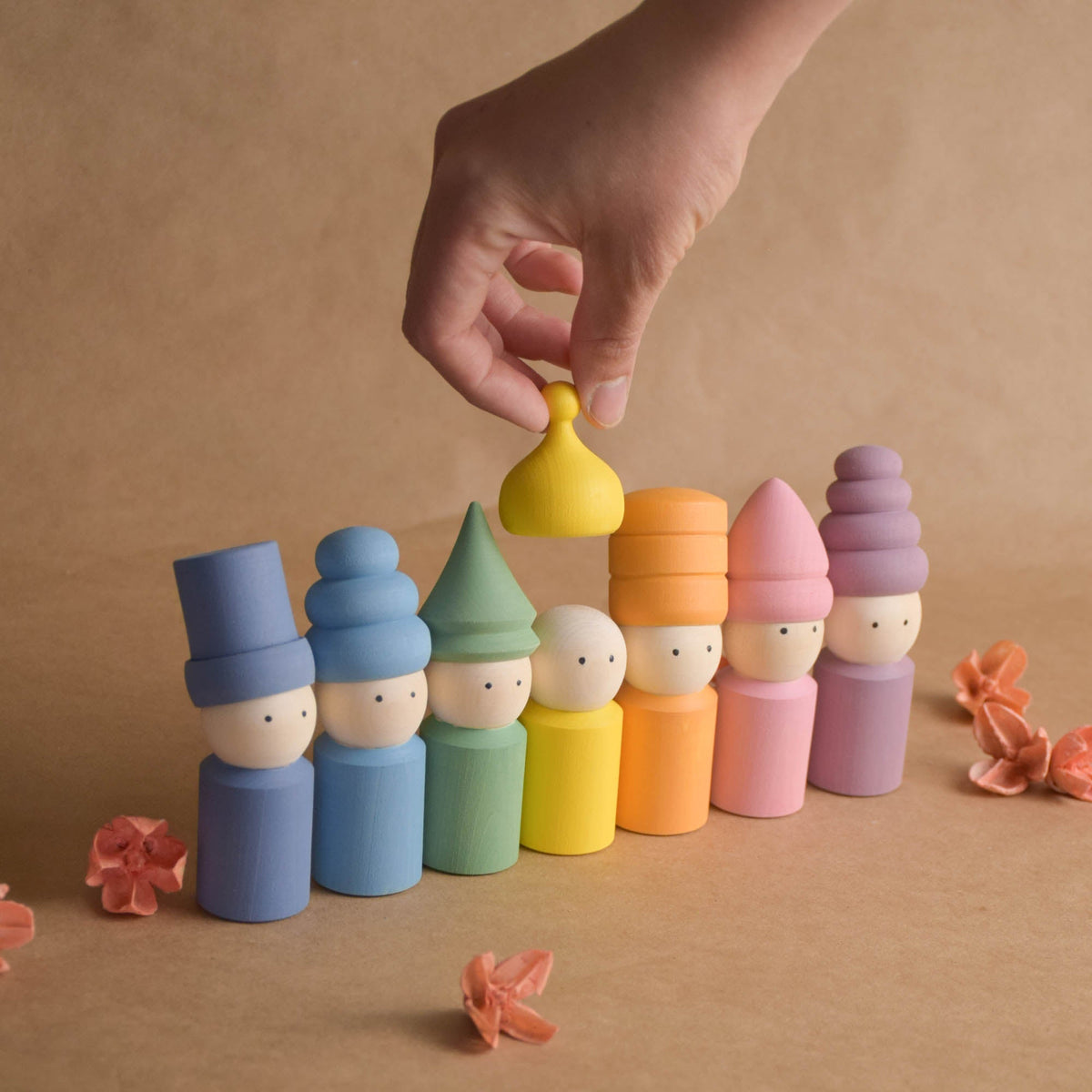 Wooden peg dolls with pastel-colored hats