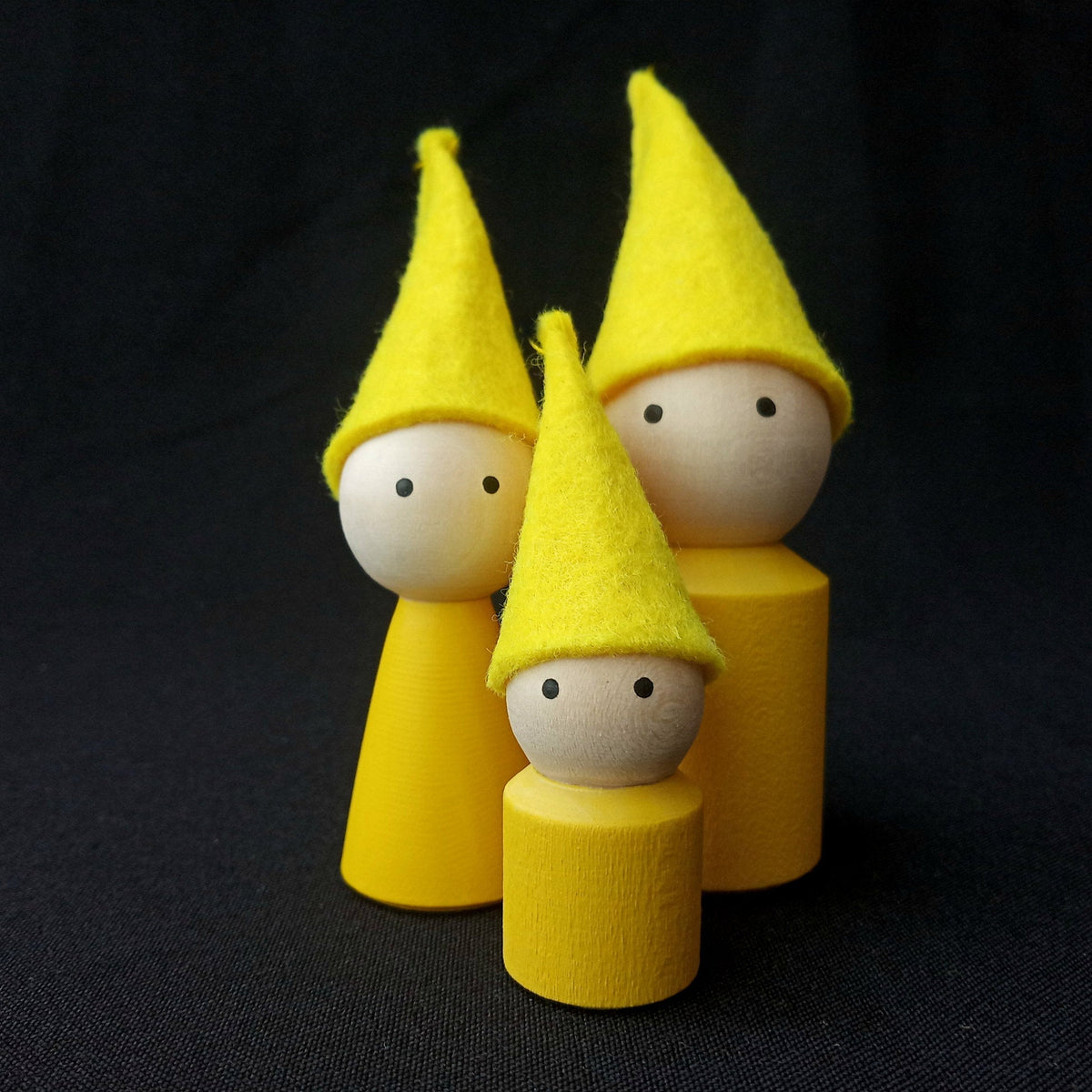 Family of wooden peg dolls with felt caps