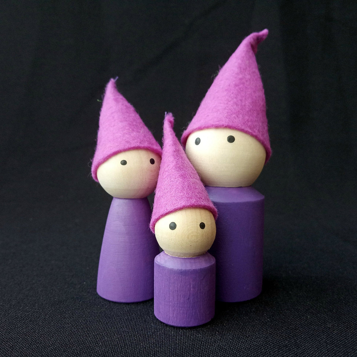 Family of wooden peg dolls with felt caps