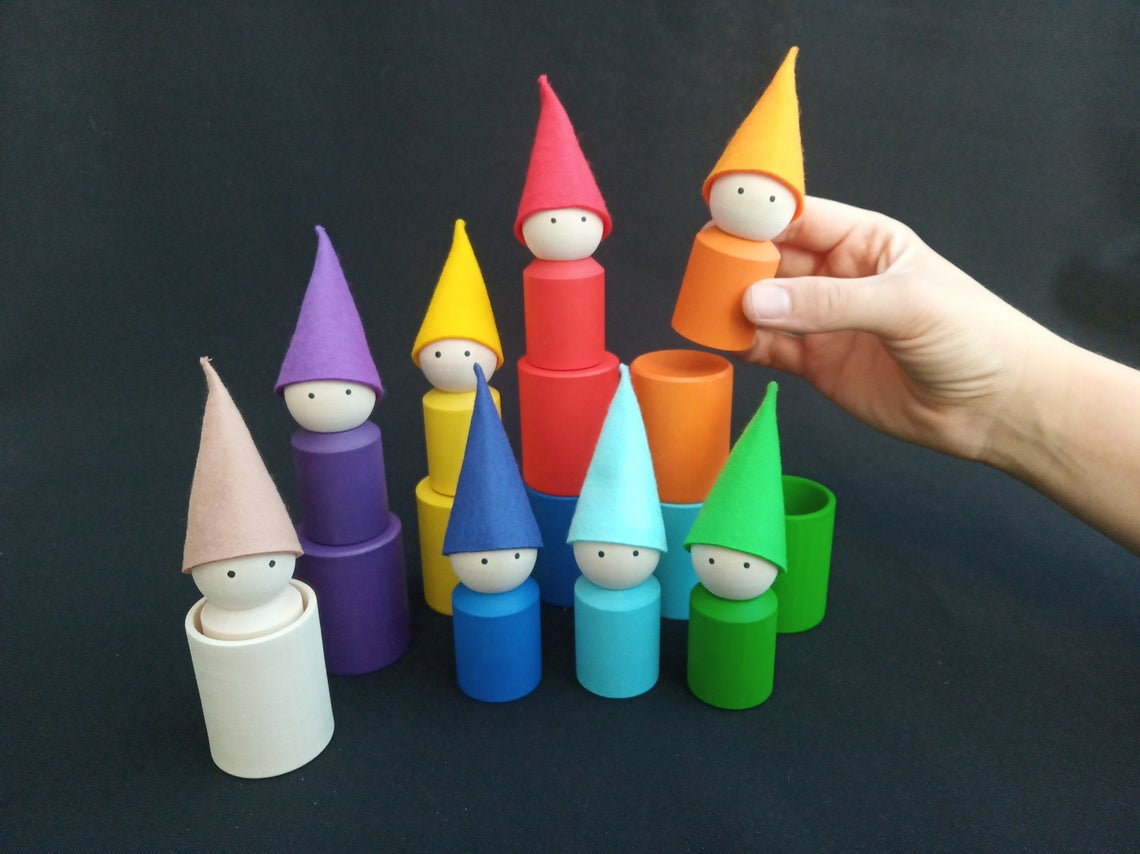 Colorful wooden cups and peg dolls with hats