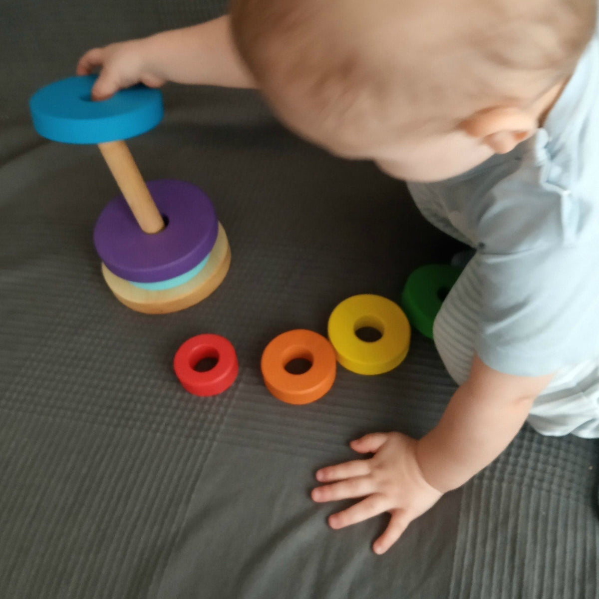 Stacking toy with rainbow-colored rings made from linden wood