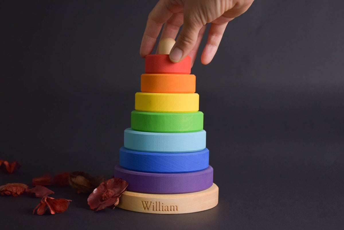 Stacking toy with rainbow-colored rings made from linden wood