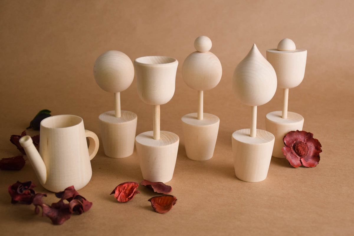 Six handmade wooden flowers and watering can