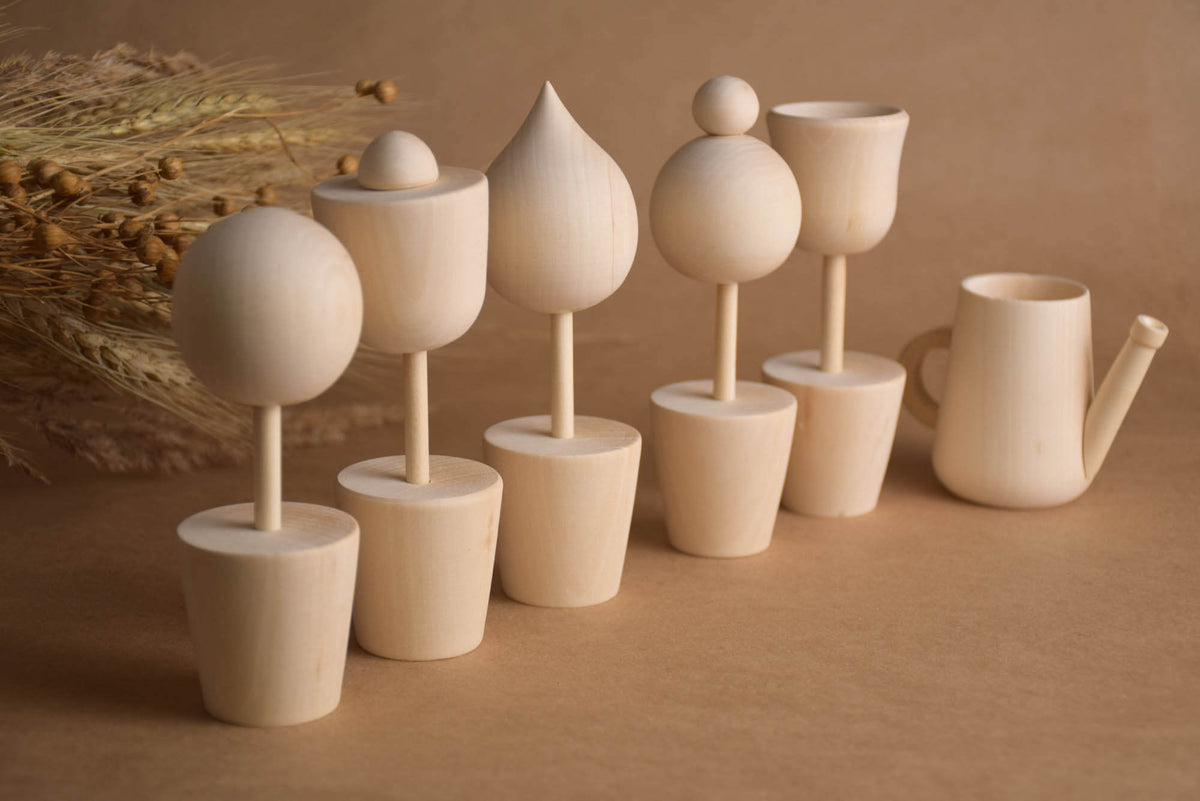 Six handmade wooden flowers and watering can