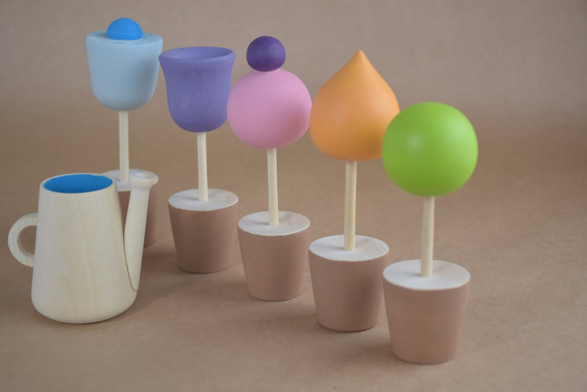 Six wooden flowers and a watering can